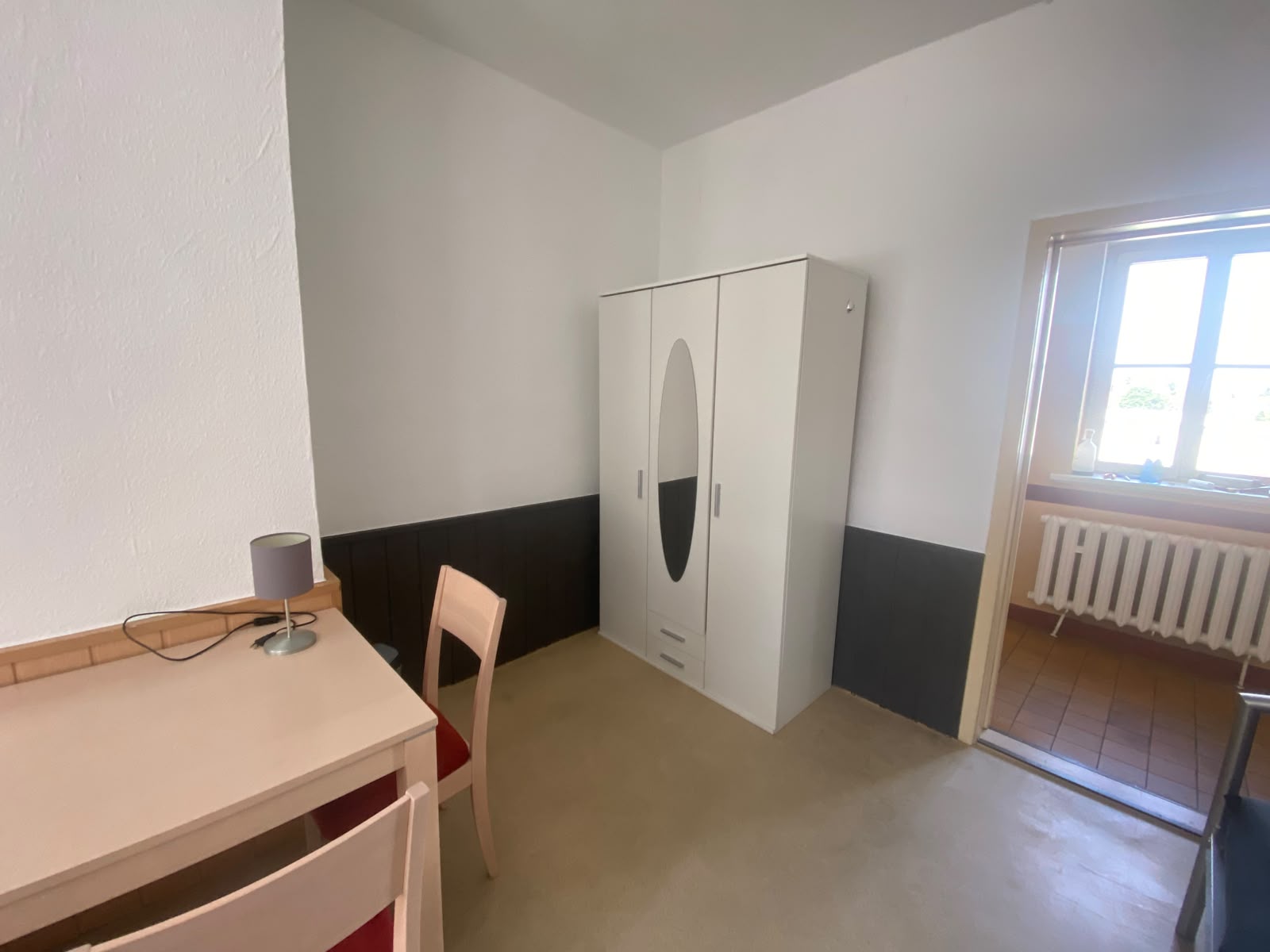 Renoviertes Zimmer mit weißem Kleiderschrank und Schreibtisch