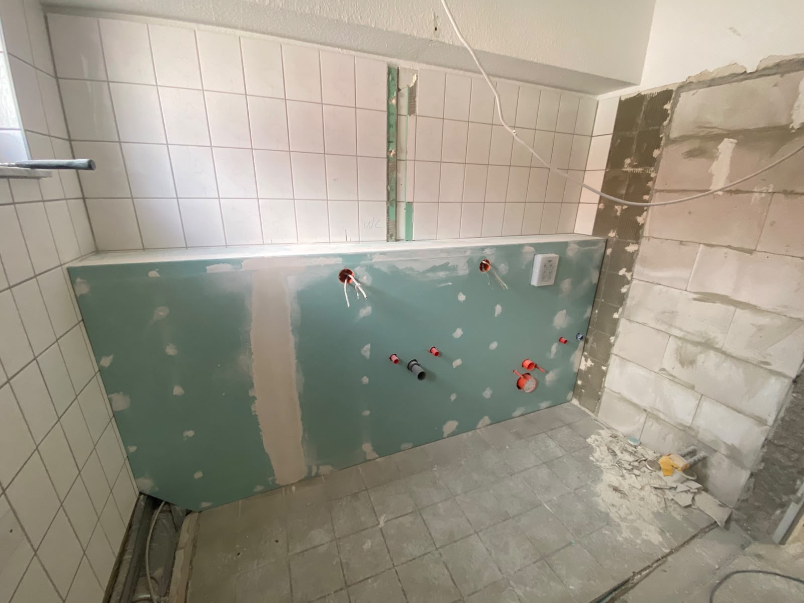 Montierte Vorwand mit Wasser- und Abwasseranschlüssen im Bad