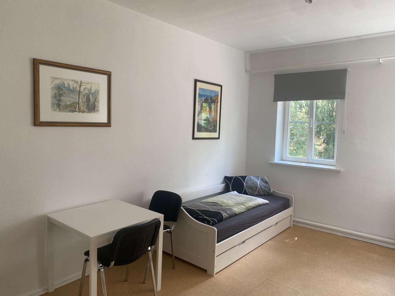 Helles Gästezimmer mit Tisch, Stühlen und Bett
