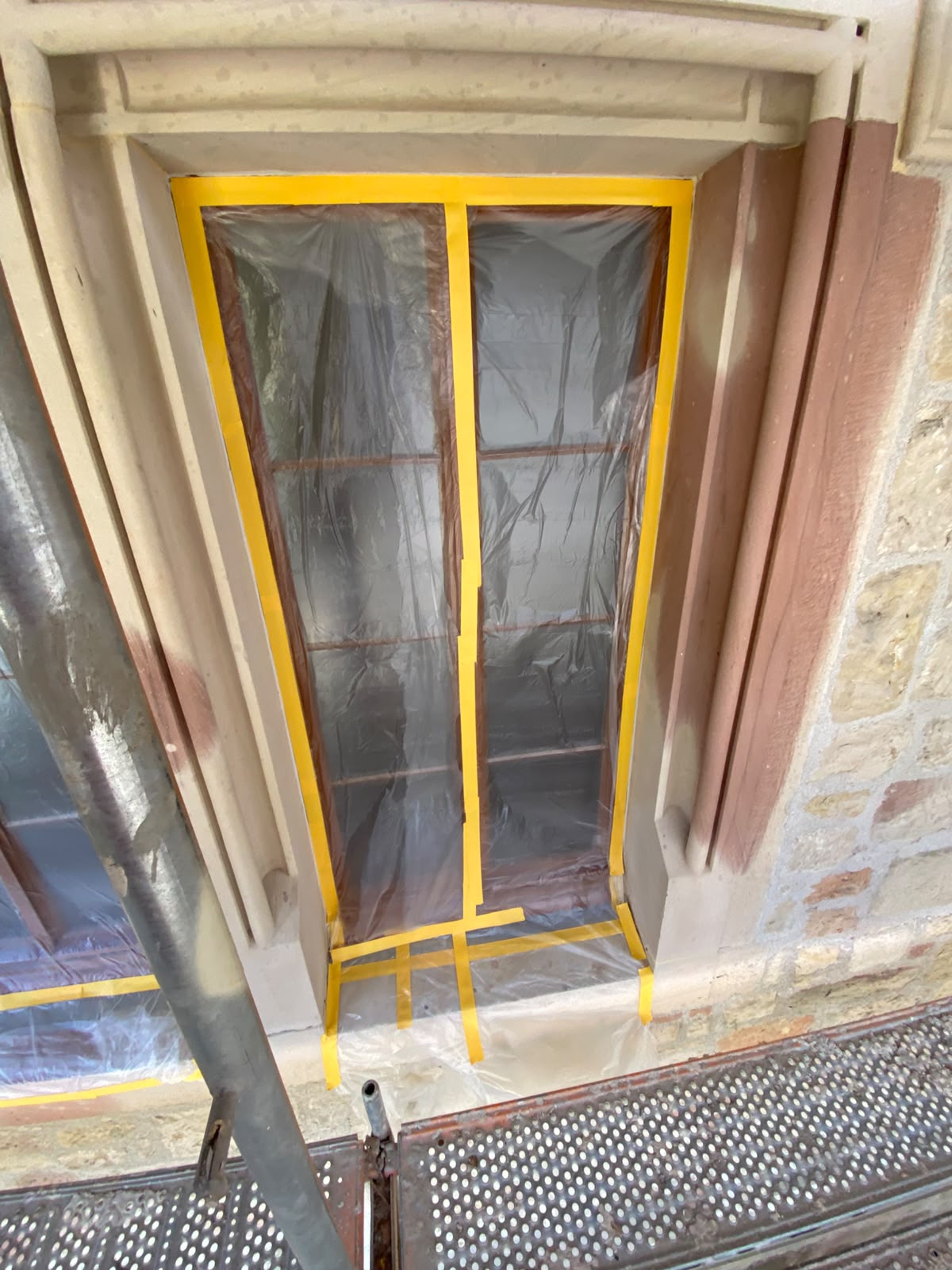 Abgeklebtes Fenster in der Sandsteinfassade von außen